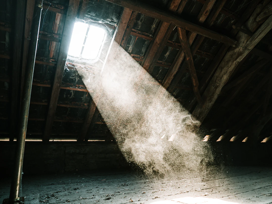 Light shining through gaps in the roof boards of a dark attic