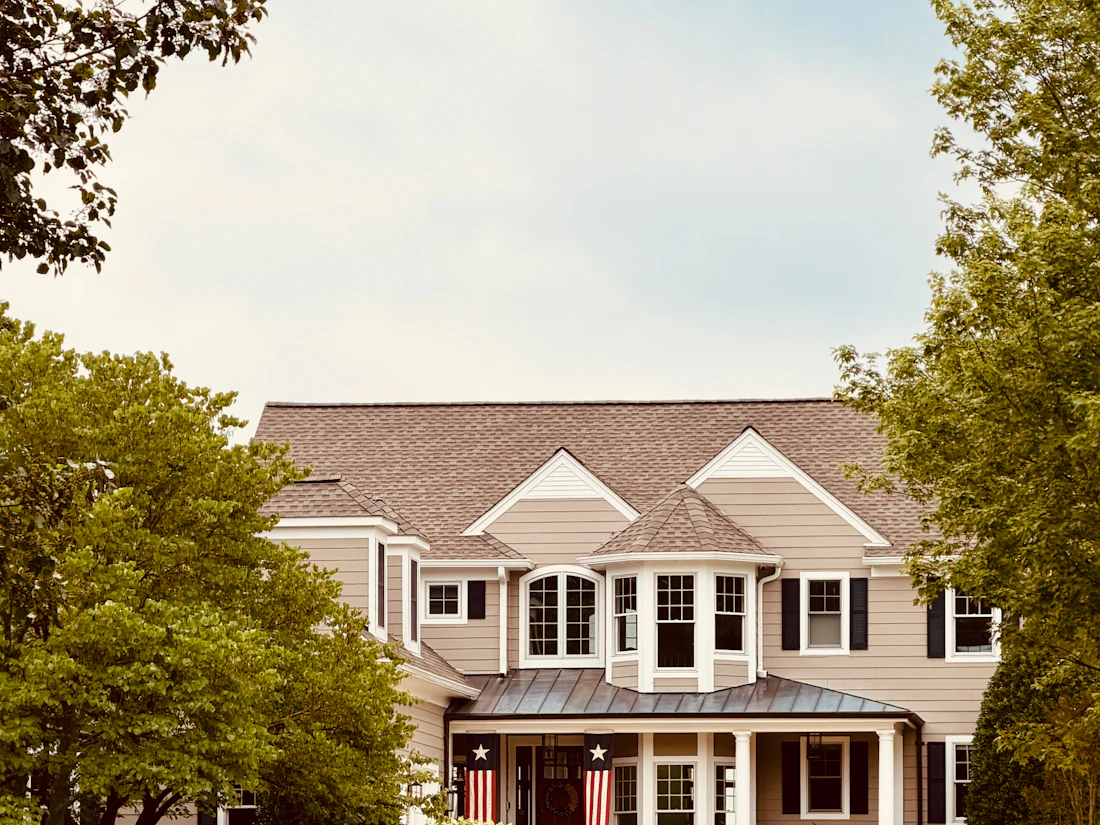 Large two-story home with several gables and dormers behind a curved driveway