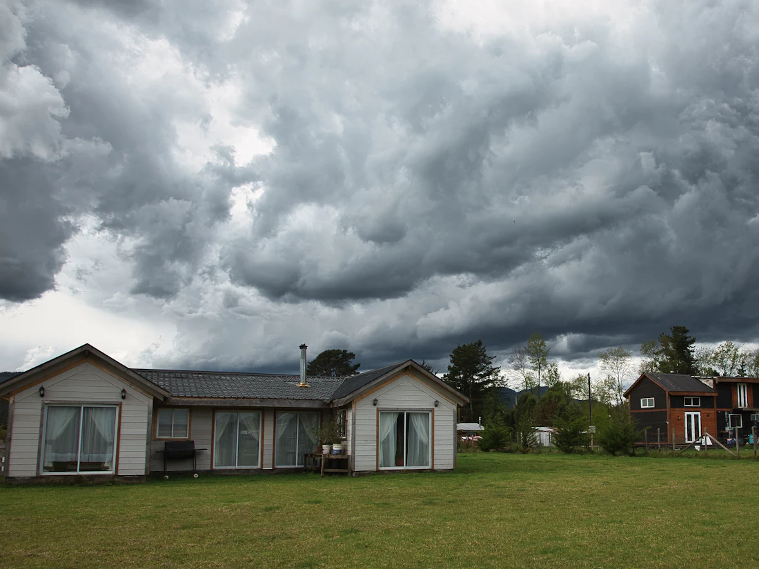 Dark storm clouds building over homes on open land
