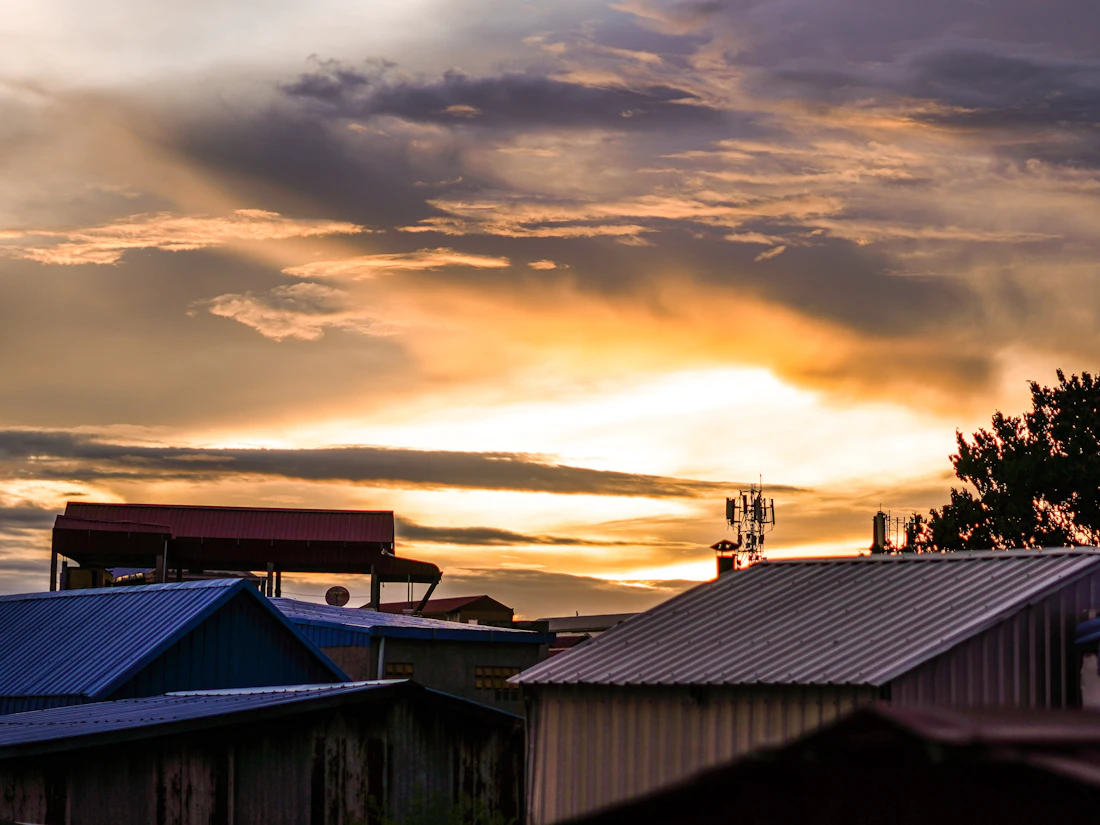 Dramatic sunset clouds over neighborhood rooftops