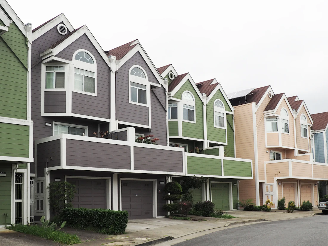 Row of attached townhomes with repeating gables and garages